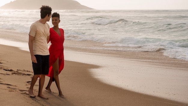 Photo gratuite couple romantique montrant de l'affection sur la plage près de l'océan