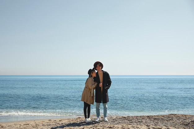 Photo gratuite couple romantique plein coup au bord de la mer