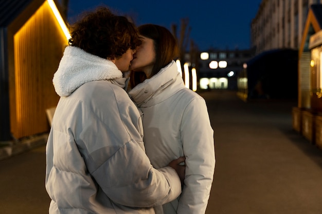 Couple romantique s'embrassant à l'extérieur la nuit