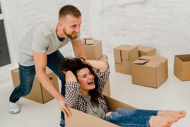 Photo gratuite couple s'amuser avec une boîte en carton