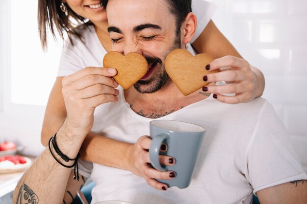Couple s&#39;amuser avec des cookies de coeur