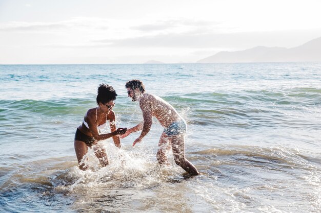 Couple s&#39;amuser dans l&#39;eau à la plage