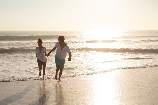 Couple s'amuser ensemble sur la plage
