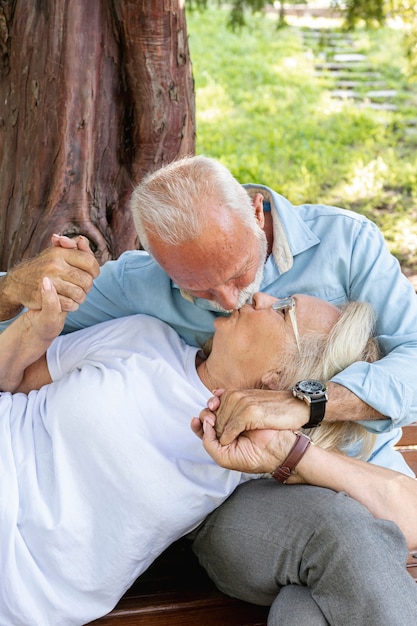 Photo gratuite couple s'embrassant sur un banc dans le parc