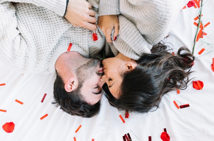 Photo gratuit couple s&#39;embrassant sur des confettis
