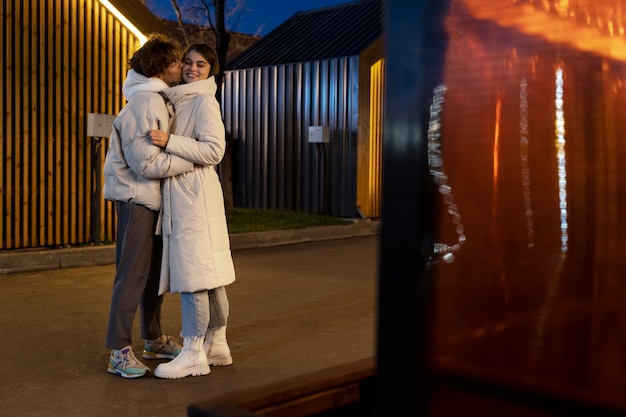 Couple s'embrassant à l'extérieur la nuit