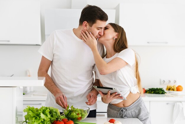 Couple s'embrassant pendant la cuisson