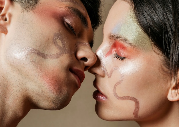 Couple s'embrassant presque avec des visages peints