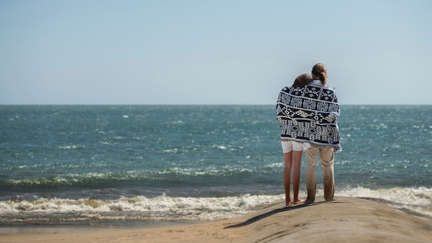 Couple se détendre sur la plage pendant les vacances