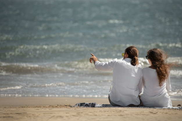 Couple se détendre sur la plage pendant les vacances