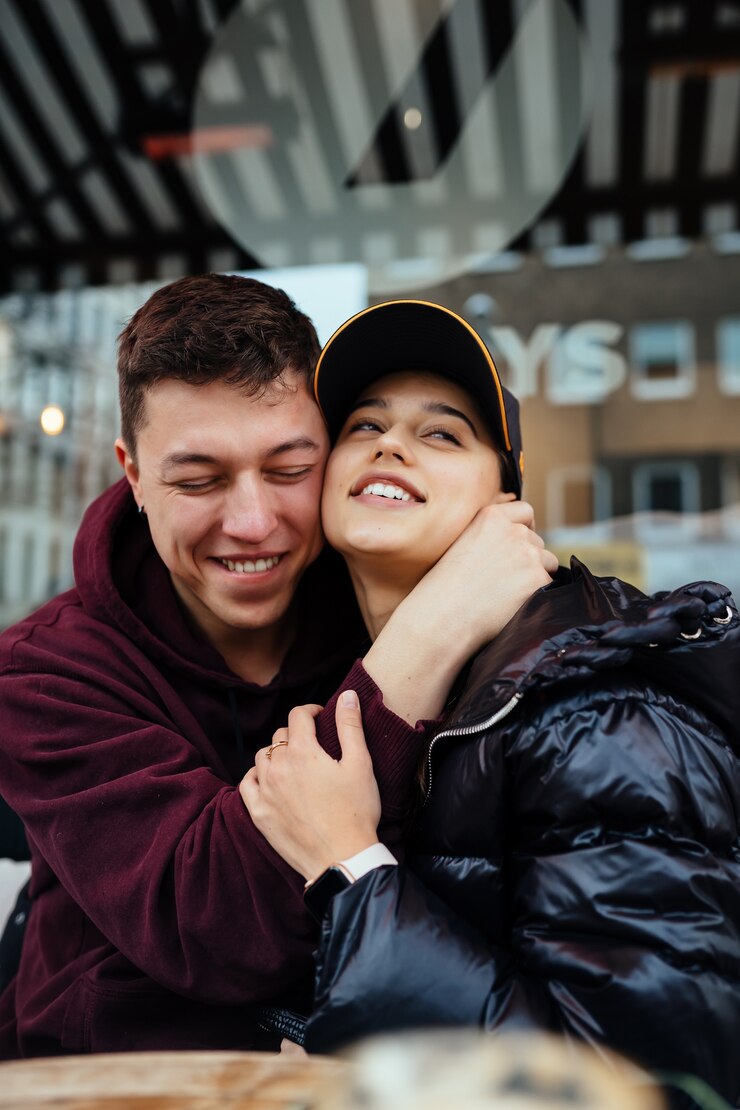 Photo gratuit couple se serre à une table dans un café en plein air