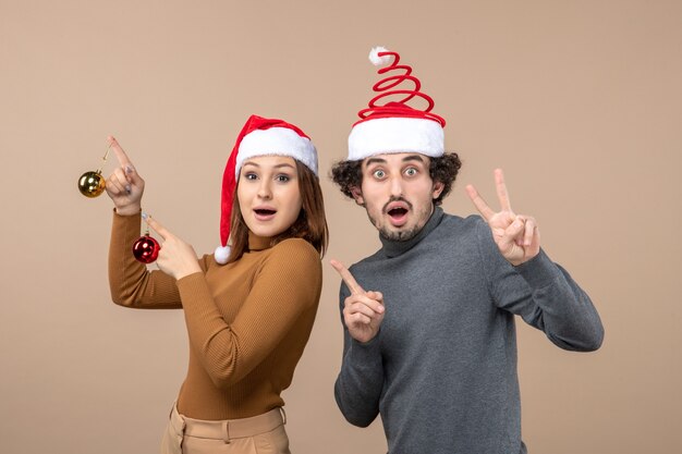 Un couple se tient à côté du sapin de Noël