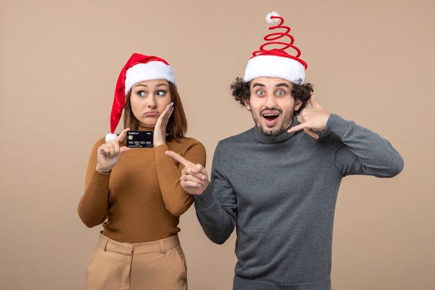 Un couple se tient à côté du sapin de Noël