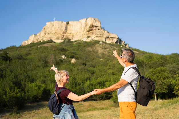 Couple senior shot moyen pointant sur la falaise