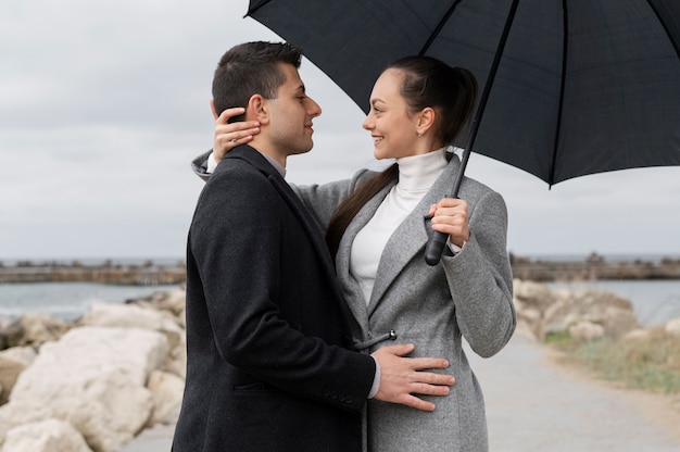 Couple smiley coup moyen avec parapluie