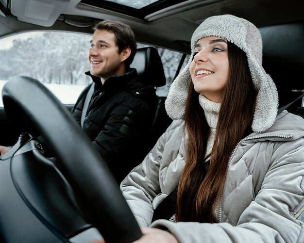 Couple Smiley ensemble dans la voiture lors d'un road trip