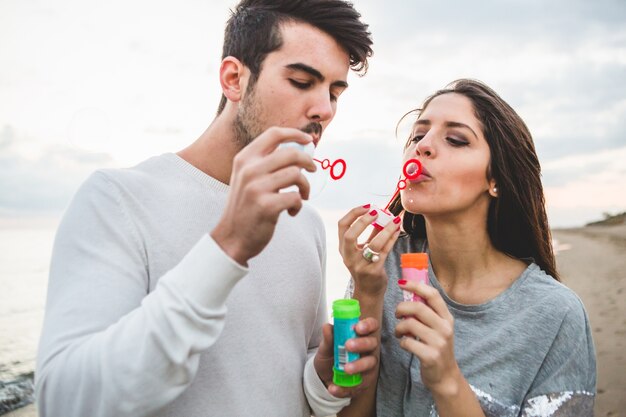 Couple soufflant des bulles de savon