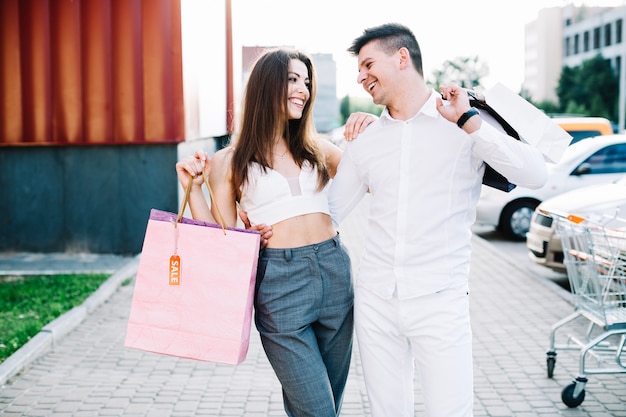 Photo gratuite couple souriant après le shopping