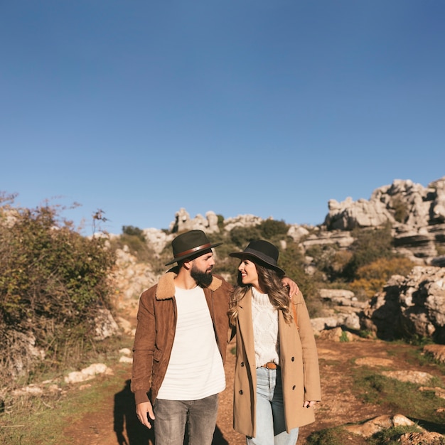 Couple souriant ayant un voyage en montagne