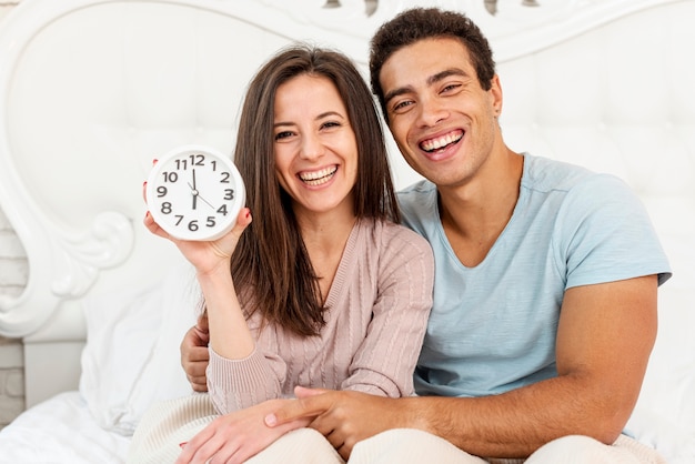 Photo gratuite couple souriant avec coup d'horloge