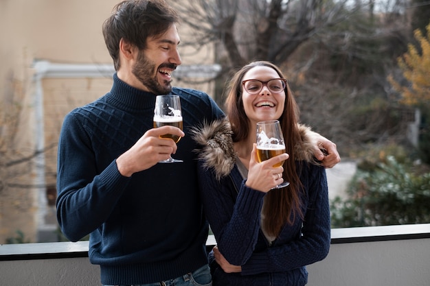 Couple souriant à coup moyen avec des boissons