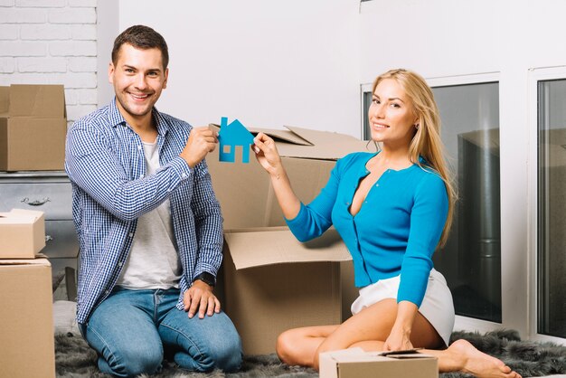 Couple souriant avec figurine de maison