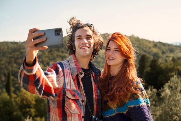 Couple souriant à plan moyen prenant un selfie