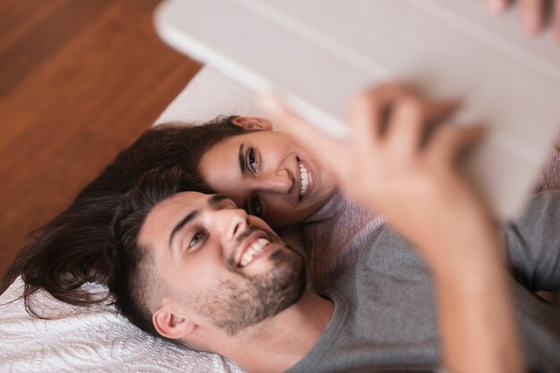 Couple souriant à la tablette