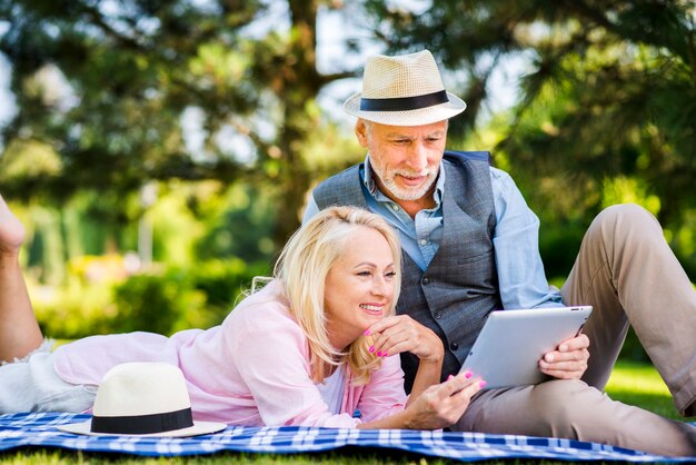 Couple souriant tenant une tablette