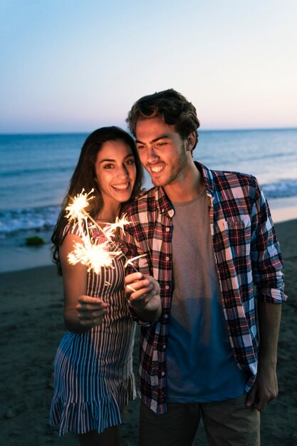 Couple avec sparkler à la plage