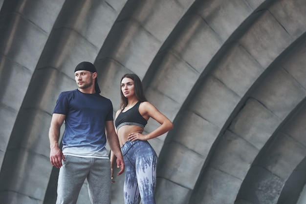 Un couple de sportifs au repos après une séance d'entraînement est une femme sexy et un homme.