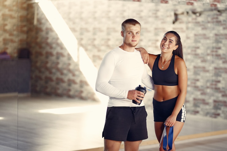 Photo gratuit couple de sportifs dans une formation de vêtements de sport dans une salle de sport