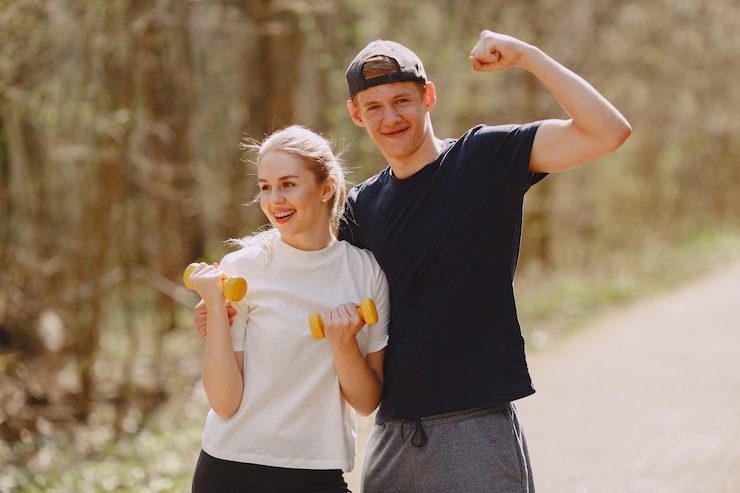 Photo gratuit couple de sportifs s'entraînant dans une forêt d'été