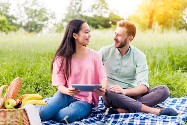 Couple avec tablette dans le parc