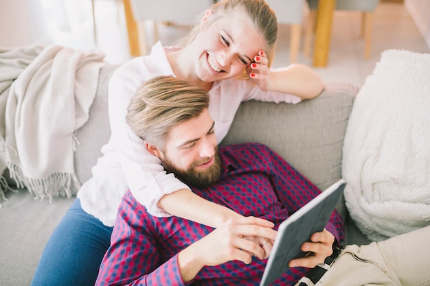 Couple avec tablette à la maison