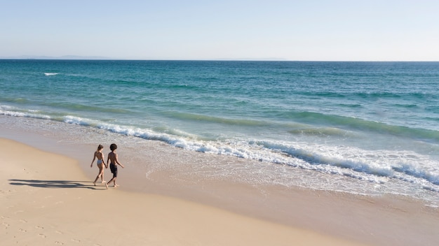 Photo gratuite couple tenant les mains et aller en mer