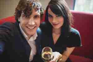 Photo gratuite couple tenant un verre et prenant un selfie