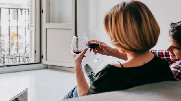 Couple tinter le vin rouge sur le canapé