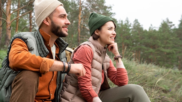 Photo gratuite couple de tir au milieu assis sur l'herbe