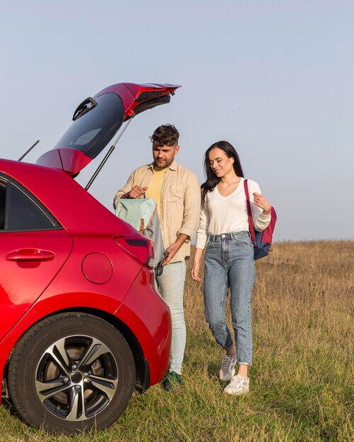 Couple de tir complet avec des sacs à dos à l'extérieur