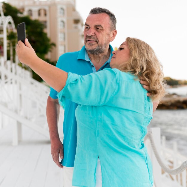 Couple de touristes aînés prenant un selfie à la plage