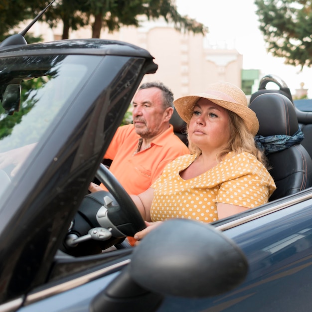 Couple de touristes aînés en vacances en voiture