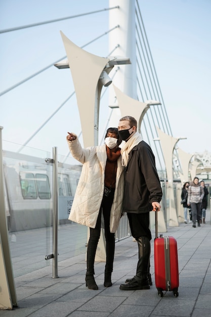 Couple de touristes à l'extérieur avec une valise