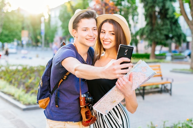 Couple de touristes prenant selfie dans le parc