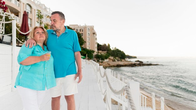 Couple de touristes senior ensemble sur la plage