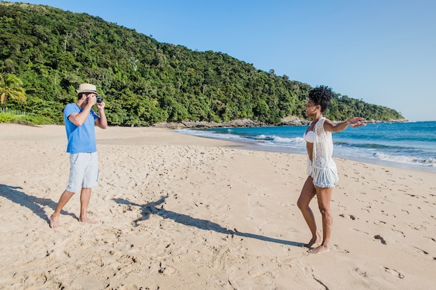 Photo gratuite couple en train de prendre des photos à la plage