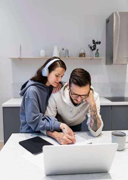 Couple travaillant ensemble depuis la cuisine à domicile