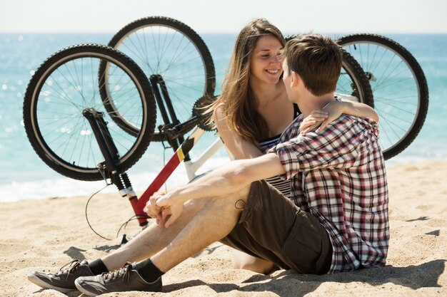 Couple avec des vélos sur la plage