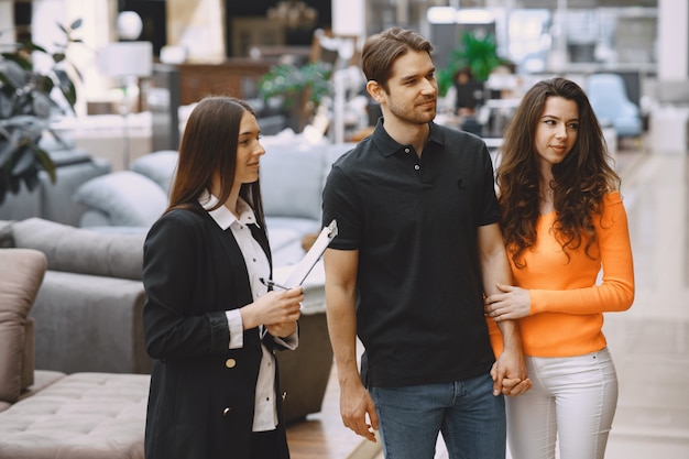 Couple avec vendeur en magasin de meubles