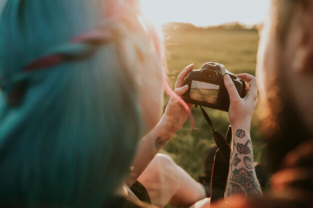 Couple vérifiant les photos sur la prise de vue en plein air de l'appareil photo